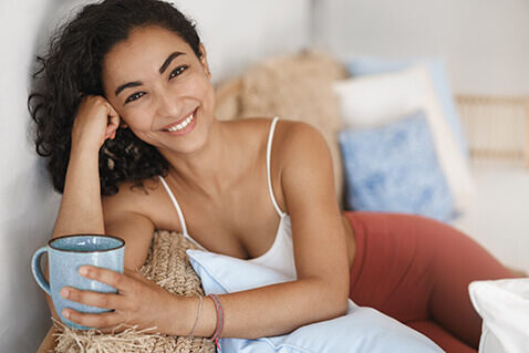 Attractive woman on couch holding mug mug