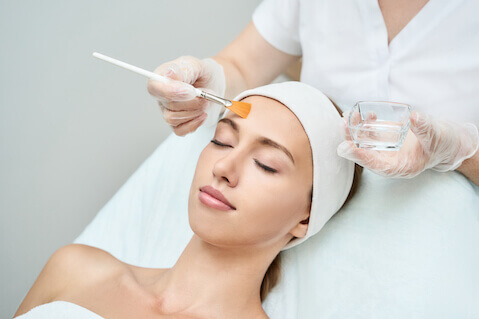 Woman getting chemical peel facial treatment
