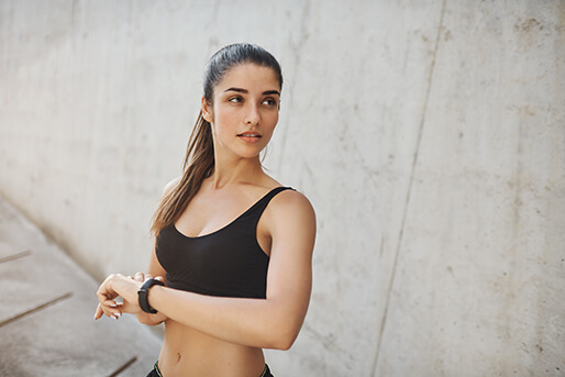 Athletic woman checking pulse during run