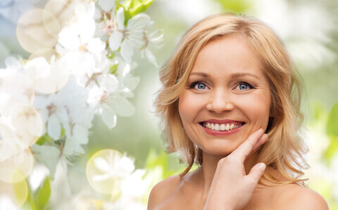Woman with smooth skin outside in flower garden
